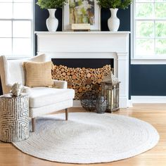 a living room with blue walls, white furniture and a fire place in the corner