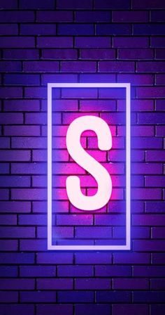 a neon sign with the letter s on it in front of a brick wall background