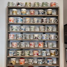 a wooden shelf filled with lots of coffee mugs