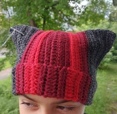 a close up of a person wearing a knitted hat with cats ears on it