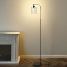 a lamp that is on top of a wooden floor next to a fire place in a room