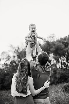 a man holding up a baby in the air