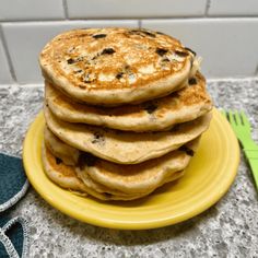 a stack of pancakes sitting on top of a yellow plate