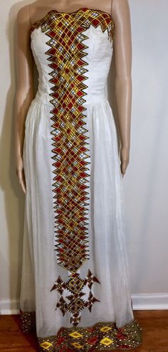 -Custom-made Ethiopian & Eritrean Dress. -This order takes approximately 4-5 weeks to make and deliver. -We will contact you about measurements instructions upon purchase. -You are allowed to change the colors and design. - Ethiopian dress - Eritrean dress - Habesha Kemis - Ethiopian Wedding - Eritrean Wedding - Habesha wedding - Zuria - Eritrean Traditional Dress -Ethiopian Traditional Dress -Ethiopian kids clothing -Eritrean kids clothing -Ethiopian men clothing -Eritrean men clothing Embroidered White Maxi Traditional Wear, White Embroidered Maxi Traditional Wear, Traditional White Maxi Dress With Intricate Embroidery, White Dresses With Embroidered Border And Traditional Drape, Traditional Wear Maxi Length For Ceremonies, Traditional Fitted Dresses For Ceremonies, Fitted Wedding Dress With Woven Motifs, Fitted Dresses With Traditional Patterns And Drape, White Dresses With Weaving Work For Traditional Ceremonies