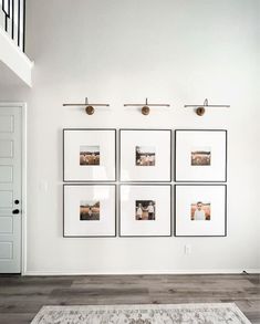 a white room with four pictures hanging on the wall and a rug in front of it