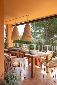 an outdoor dining area with wicker chairs and table on tiled floor next to balcony