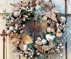 a wreath is hanging on the front door with pine cones and other holiday decorations around it