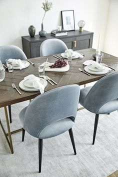 the table is set with plates and silverware on it, along with other place settings