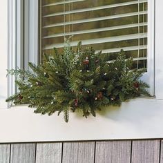 a window sill decorated with pine cones and berries