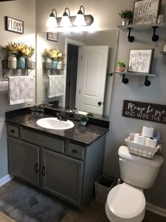 a bathroom with a toilet, sink and mirror in it's centerpieces