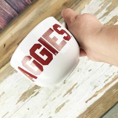 a hand holding a coffee mug with the word class on it in red and white