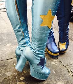 two people wearing blue boots with yellow stars on the side and one person's legs