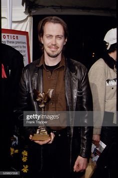 a man in leather jacket holding an award for his role as the lead character on tv