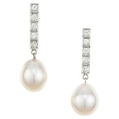 Pearl and diamond dangle earrings. 2 freshwater cultured white pearl drops measuring 11.5mm, each attached to a 14k white gold row of 5 frame set brilliant cut diamonds. Elegant but simple. 10 round brilliant cut diamonds, G-H SI approx. .40cts 2 freshwater white pearl drops, good lustre, silver overtone 11-11.5mm 14k white gold Stamped: 14k 7.3 grams Top to bottom: 33.8mm or 1.33 Inches Width: 16.9mm or .43 Inches Depth or thickness: 11.0mm Please Note, we photograph each item as accurately as Elegant Platinum Pearl Earrings For Formal Occasions, Classic Silver Platinum Pearl Earrings, Classic Platinum Pear-shaped Diamond Earrings, Classic White Gold Pearl Earrings, Elegant Platinum Pearl Earrings For Anniversary, Classic Platinum Pearl Earrings For Formal Occasions, Diamond White Pearl Drop Earrings For Formal Events, Elegant Platinum Pearl Earrings For Wedding, Classic Diamond White Pearl Drop Earrings