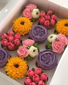 cupcakes decorated with flowers in a box