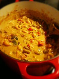 a red pot filled with food on top of a stove