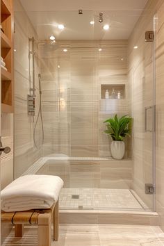 a bathroom with a glass shower door and white towels on the bench next to it