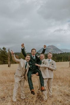 three men in suits and ties are posing for the camera with their arms raised up