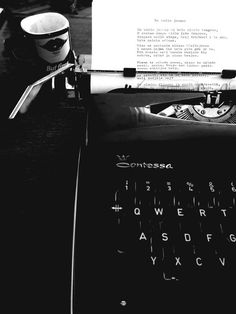 an old fashioned typewriter sitting on top of a table next to a coffee cup