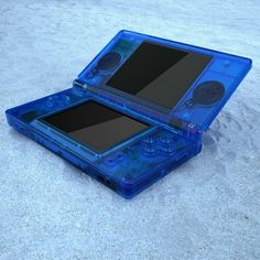 an open blue plastic case sitting on top of sand