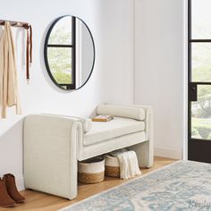 a white bench sitting in front of a mirror on the wall next to a rug