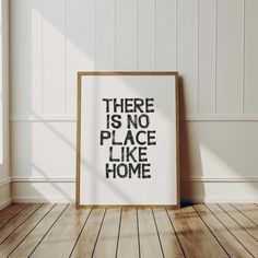 there is no place like home on the floor in front of a framed poster that reads, there is no place like home