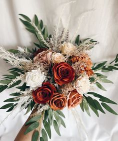 a bouquet of flowers is sitting on a white sheet