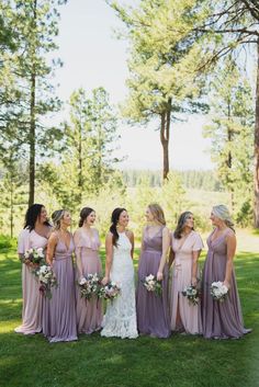 a group of women standing next to each other on top of a lush green field