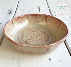 a brown and white bowl sitting on top of a wooden table