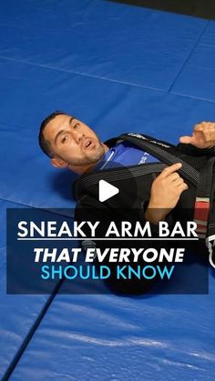 a man laying on top of a blue mat holding a black bag with the words sneaky arm bar that everyone should know