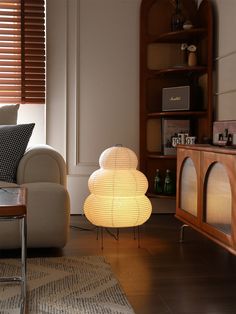 a living room with a couch, chair and lamp on the floor in front of it