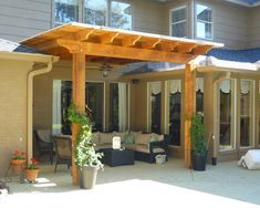 a covered patio with furniture and potted plants