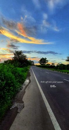 an empty road with the sun setting in the background and a quote written on it