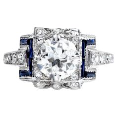 This Vintage art Deco Ring ring is crafted in solid Platinum With a geometric, mill-grain deco design. It is centered with a genuine vintage European-cut Diamond; prong Set weighing 1.61cts, I-J color, SI2 Clarity. Adding a touch of color (8) Sapphire, baguette-cut, channel set, and 12 round diamonds weighing approx. 0.30 carats H-I SI clarity The ring size is 7.75, Sizable. Purity Hallmarked & Excellent Condition. This ring comes with a professional appraisal. Vintage Gia Certified Sapphire Jewelry, Luxury Antique Sapphire Ring With Brilliant Cut, Luxury Art Deco Multi-stone Sapphire Ring, Exquisite Gia-certified Platinum Sapphire Ring, Exquisite Diamond-cut Sapphire Ring, Vintage Art Deco Rings, Platinum Engagement Rings, Deco Ring, European Cut Diamonds