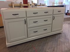 an unfinished kitchen with white cabinets and wood floors