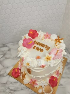 a birthday cake decorated with flowers on a table