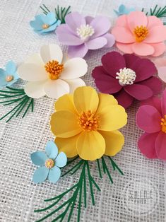 paper flowers are arranged on a table cloth