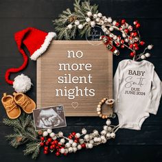 a baby's first christmas outfit and other items laid out on a black surface