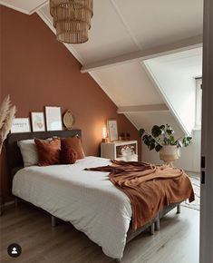 a bedroom with an orange wall and white bedding