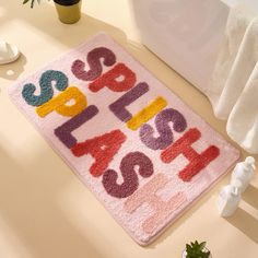 a bath mat with the words happy birthday on it next to a potted plant