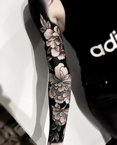 a woman with black and white flowers on her arm