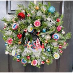 a wreath with ornaments hanging on the front door