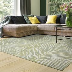 a living room filled with furniture and a large rug on top of a hard wood floor