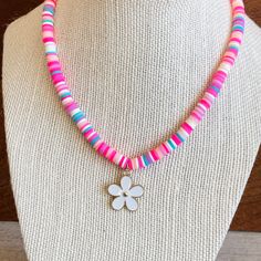 This cute FLOWER Charm necklace can make any outfit more special! Little girls will love the bright heishi beads in pink and turquoise and cute flower charm! This stretchy necklace fits right over your head so it's easy to put on- no clasps needed. Our custom jewelry is made to order so all sales are final. The necklace is beautifully packaged and ready to gift. Receipts are never included. If you want to include a special note, please let me know in the comments. Please be advised small parts c Cute Flower Beaded Necklaces With Colorful Beads, Cute Flower-shaped Colorful Beaded Necklaces, Whimsical Pink Jewelry For Beach, Whimsical Pink Beach Jewelry, Fun Pink Necklace For Birthday, Pink Flower Charm Jewelry For Beach, Adjustable Pink Flower Necklace, Fun Pink Jewelry With Letter Beads, Playful Pink Necklaces For Beach