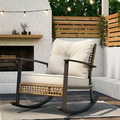 a rocking chair sitting on top of a wooden floor next to a fire place in a backyard