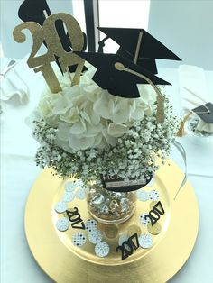 a graduation centerpiece with flowers and decorations