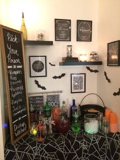 halloween decorations are displayed on the wall above a bar with liquor bottles, candles and bats