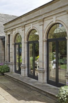 an outside view of a house with many windows and doors on the side of it