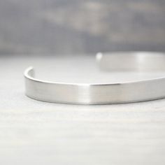 "This sterling silver inspirational bracelet will serve as a beautiful reminder. Be a voice, not an echo It's so versatile it will go well with just about anything. Please note this cuff has text that is on one end as shown in the images and is NOT centered on the cuff. ♥ 14 Gauge Hammered .925 Sterling Silver ♥ 1/4\" wide x 6\" long ♥ Easily adjustable PureImpressions.etsy.com makes these charming silver inspiration cuffs, as well as other handmade jewelry with love one at a time in the heart o Modern Personalized Silver Bracelets, Silver Adjustable Cuff Bracelet For Everyday, Adjustable Silver Cuff Bracelet For Everyday, Minimalist Stainless Steel Bangle For Anniversary, Minimalist Stainless Steel Anniversary Bangle, Classic Stainless Steel Cuff Bracelet For Everyday, Minimalist Silver Cuff Bracelet With Hand Stamped Details, Minimalist Engraved Adjustable Cuff Bracelet, Minimalist Adjustable Nickel-free Cuff Bracelet