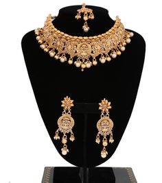 "A magnificent Luxury bridal necklace set for the brides.Premium quality gold plated, antique design, and studded with small clear stones and beautify with round golden beads and pearls droppings. Necklace comes with matching earrings and maang tikka. 1 x Necklace approx. 4.5 inches Collar-Wide . Back adjustable rope is attached. 1 x Pair of Earrings 3.5\" Length from top to bottom. *Adjustable & Appropriate for All Neck Sizes.Perfect for a bride in wedding or party wear jewelry set. Visit m Luxury Bridal Necklace, Bridal Choker Necklace, Wedding Choker Necklace, Indian Choker Necklace, Golden Beads, Bridal Choker, Jewelry Set Design, Bridal Necklace Set, Maang Tikka